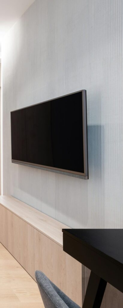 Sleek modern living room featuring a brown sofa and wall-mounted TV.